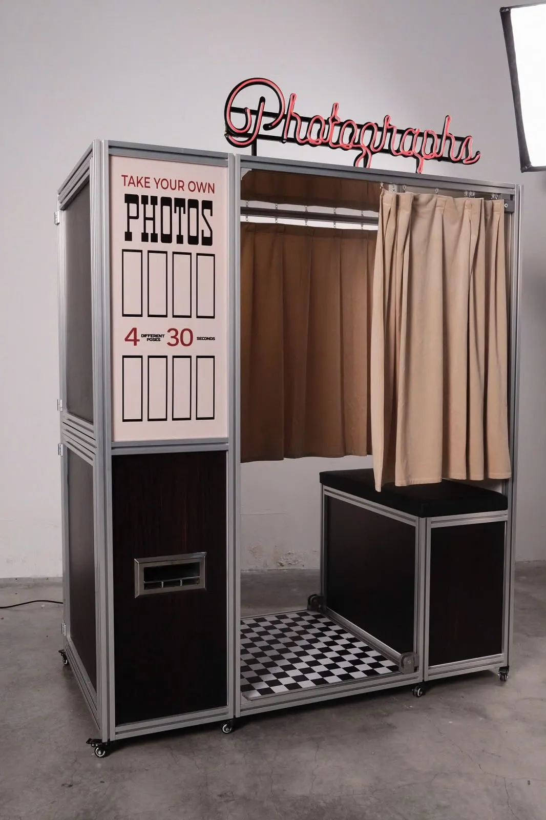The Vintage Booth enclosed photo booth with its red Photographs neon sign and velvet curtains