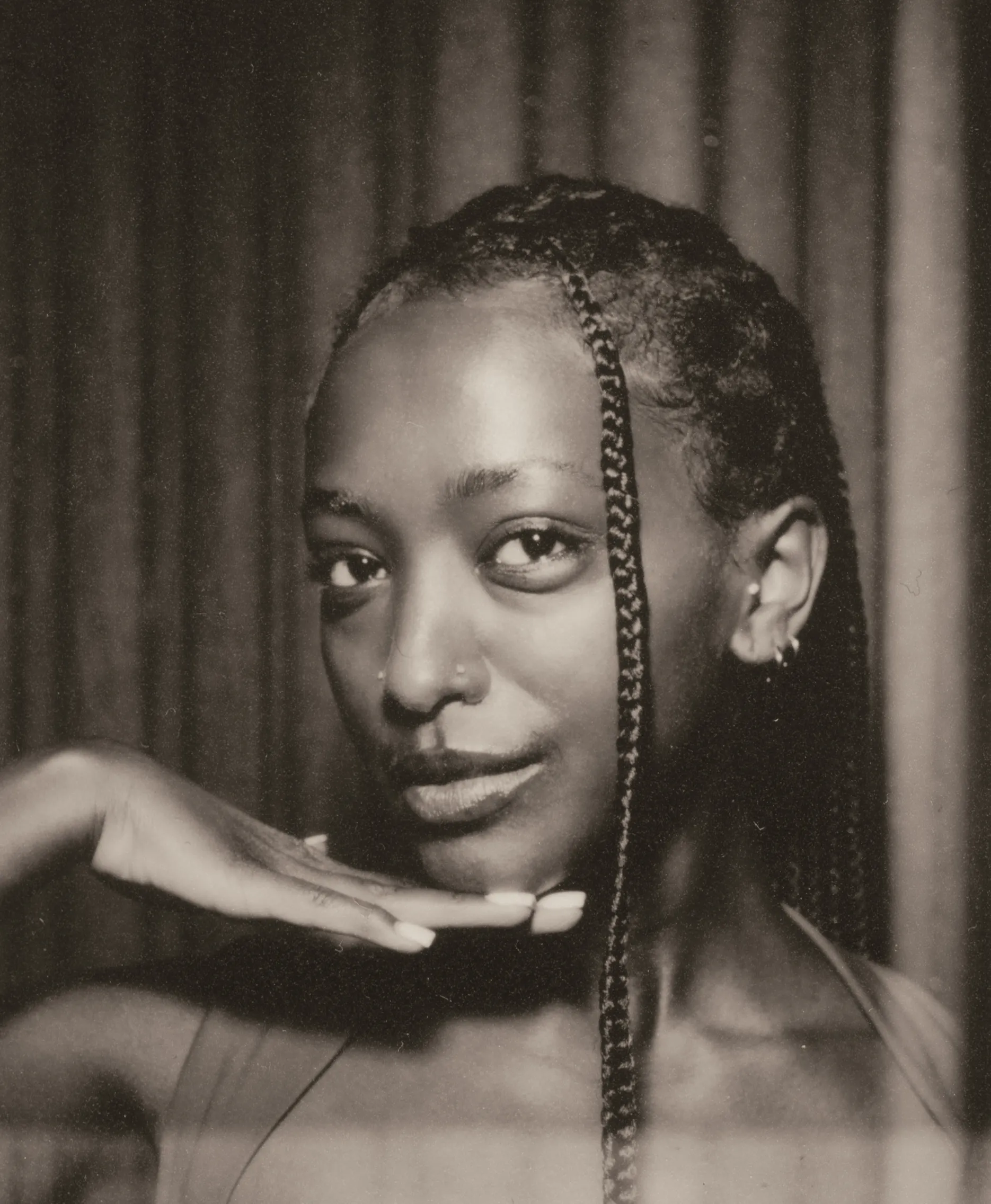 Film photo booth strip frame one: a guest posing with her hand under her chin